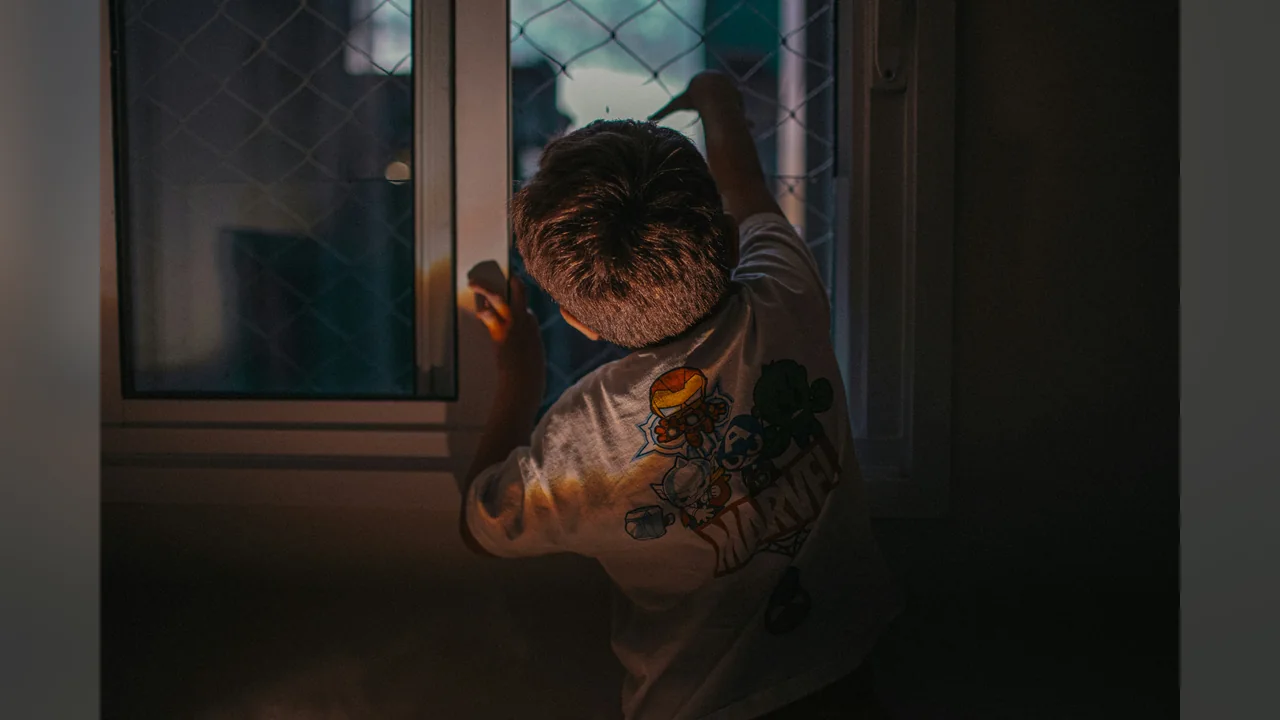 Ребёнок смотрит в домашнее окно